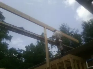 Carpenter setting a ridge beam over a new addition frame — Ice Dam Removal by Roofing Brothers in Monett